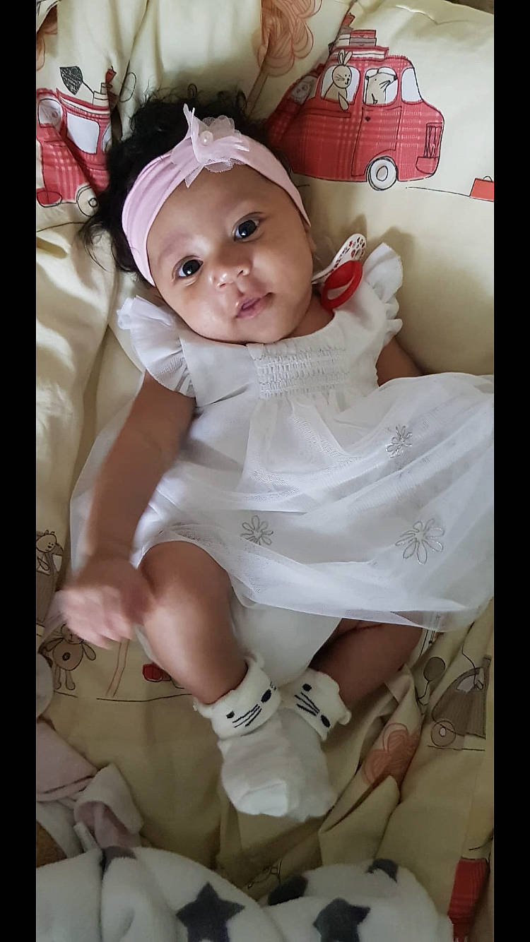 Keyla participe au concours pour gagner de l'argent avec cette photo : baby, baby_products, baby_toddler_clothing, cheek, child, dress, fashion_accessory, happy, headwear, human_leg, iris, magenta, person, pink, product, skin, sleeve, smile, sock, thigh