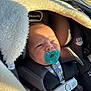 baby, pacifier, car_seat, blanket, sunlight, child, infant, straps, clothing, seatbelt, face, head, indoors, comfort, nap, safety, blue, soft_texture, closeup, portrait