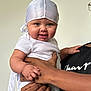 Maharmony joined the competition — help win amazing prizes! baby, child, infant, smile, white_clothing, headwear, hand, adult_hand, black_shirt, portrait, indoors, face, cute, person, holding, expression, young_child, skin, closeup, bright_eyes