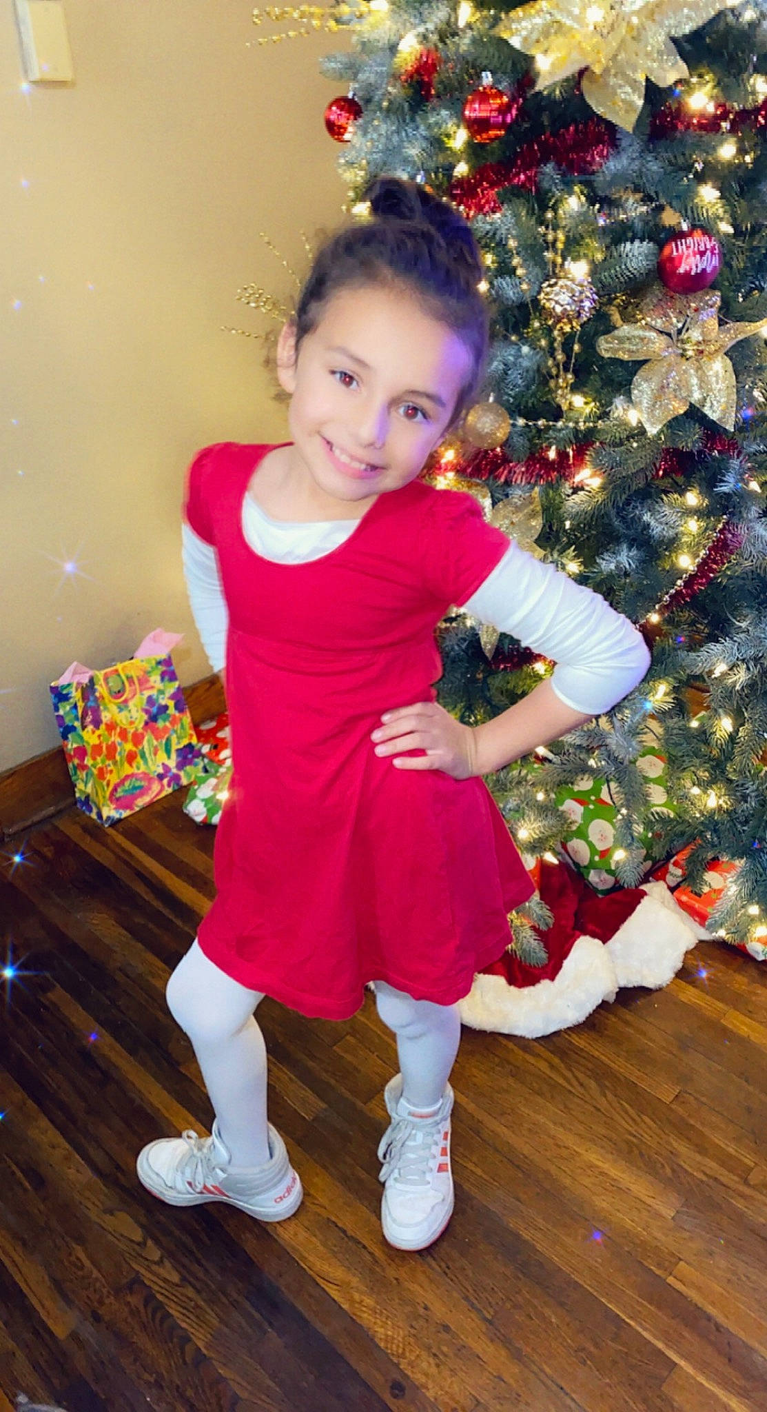 Elliana is registered to the contest to win money with this photo: baby_toddler_clothing, christmas, christmas_decoration, christmas_ornament, christmas_tree, dress, event, fun, happy, holiday, human_leg, joy, magenta, ornament, person, plant, red, sleeve, sock, toddler