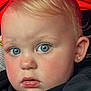 Maya is registered to the contest to win money with this photo: toddler, child, face, blue_eyes, blonde_hair, hoodie, black_clothing, pink_text, portrait, close_up, red_background, earring, young_child, cute, innocent, skin, expression, baby, person, indoor
