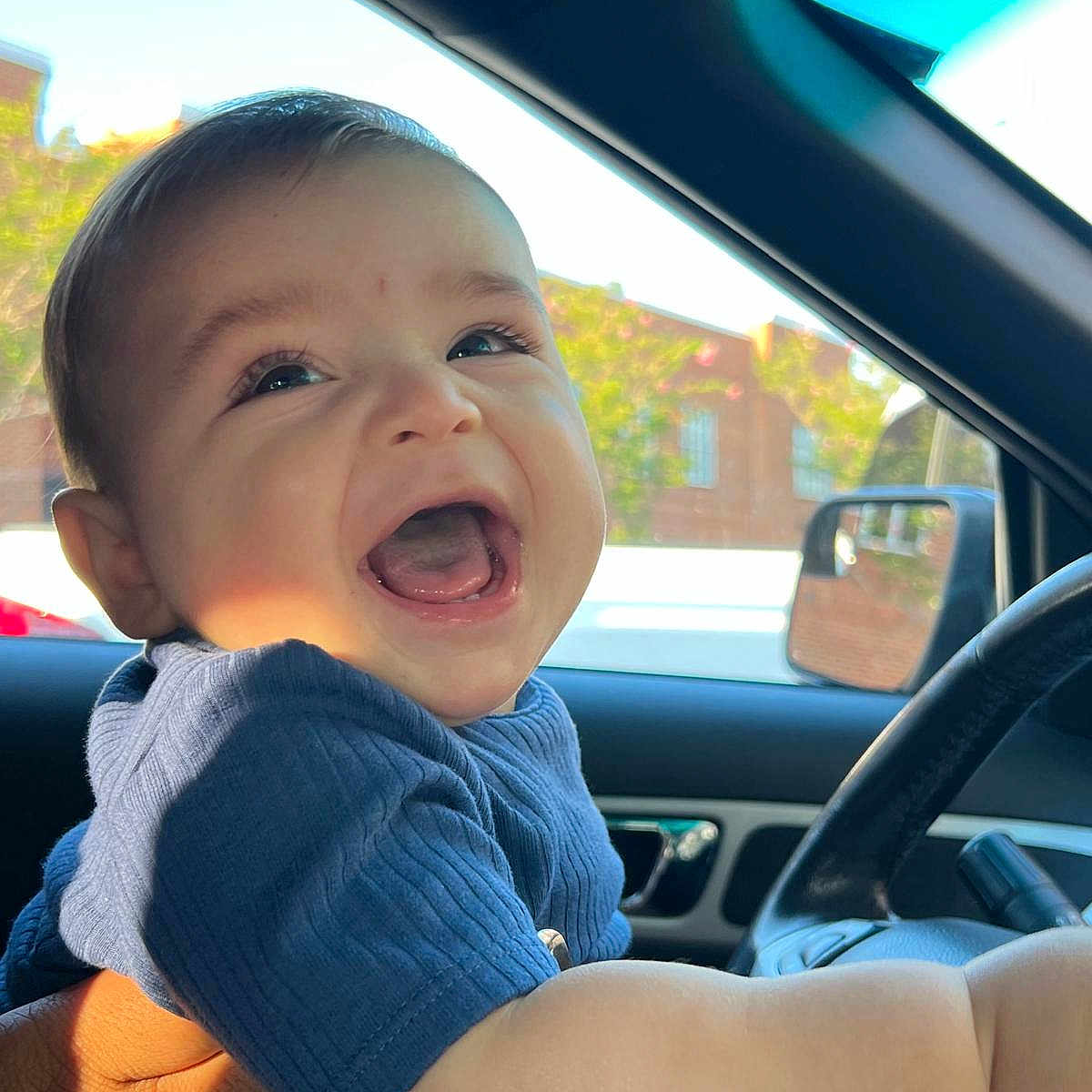 Matthias J joined the competition — help win amazing prizes! automobile, baby, blue_shirt, candid, car_interior, child, daylight, face, hand, happy, infant, laughing, person, portrait, seat, side_mirror, smiling, steering_wheel, sunlight, window