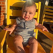 Matthias J is registered to the contest to win money with this photo: baby, child, yellow_chair, sunlight, striped_clothing, outdoor, cute, portrait, infant, smiling, sitting, summer, shadow, relaxing, playful, sunshine, skin, foot, hand, expression