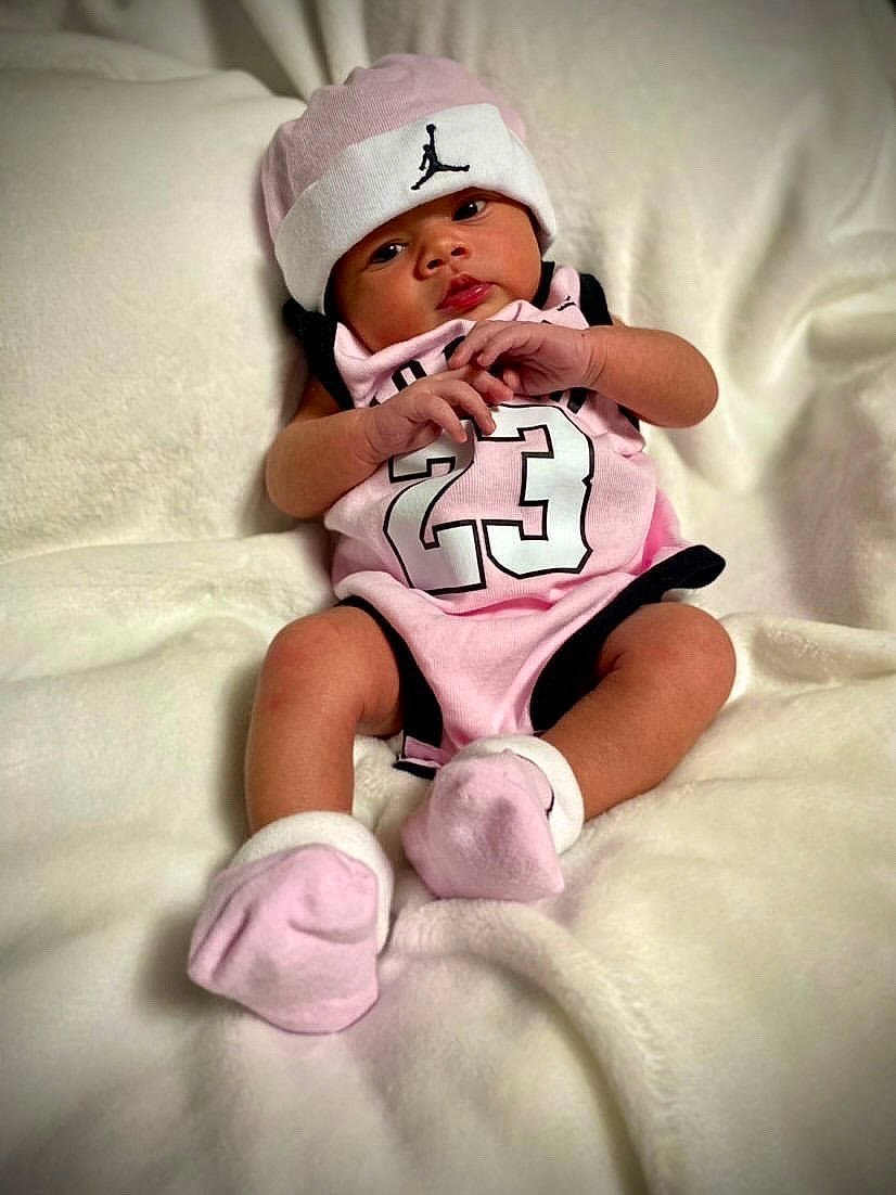 Nevaeh is registered to the contest to win money with this photo: arm, baby, baby_sleeping, baby_toddler_clothing, comfort, finger, flash_photography, gesture, hand, happy, headwear, human_leg, knee, leg, person, pink, skin, sleeve, textile, thigh