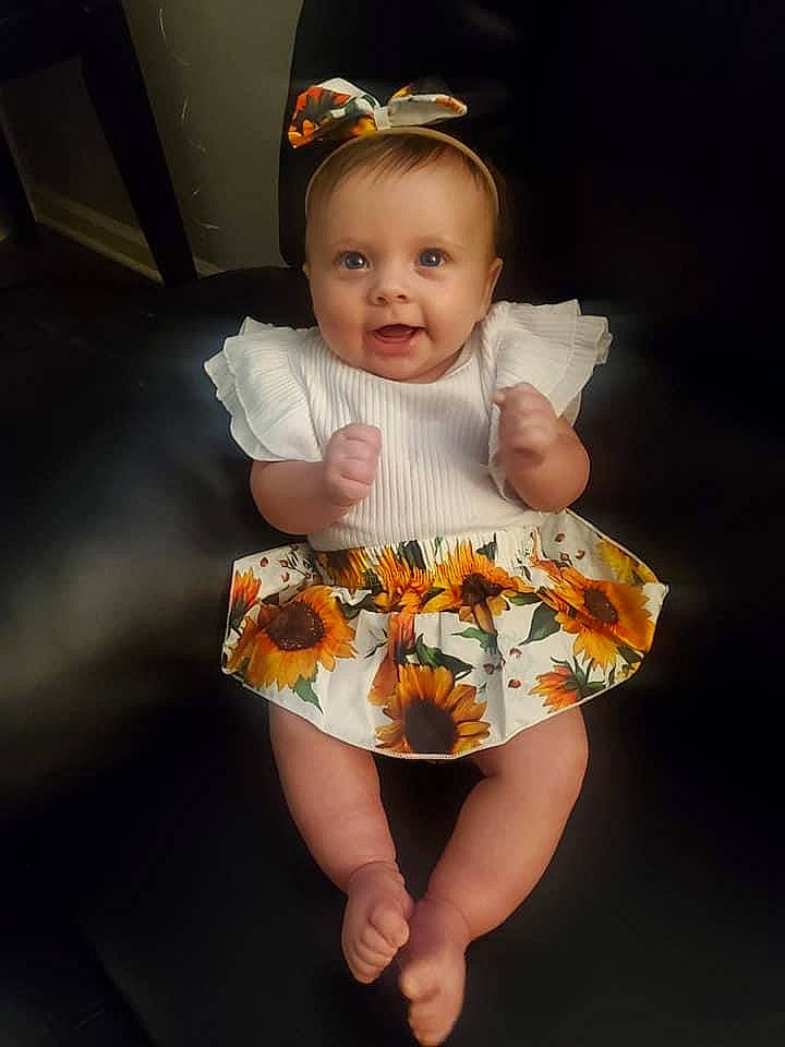 Lilly is registered to the contest to win money with this photo: baby, baby_products, baby_toddler_clothing, child, day_dress, dress, embellishment, face, fashion_accessory, happy, head, human_leg, iris, necklace, pattern, person, sleeve, smile, t_shirt, toddler