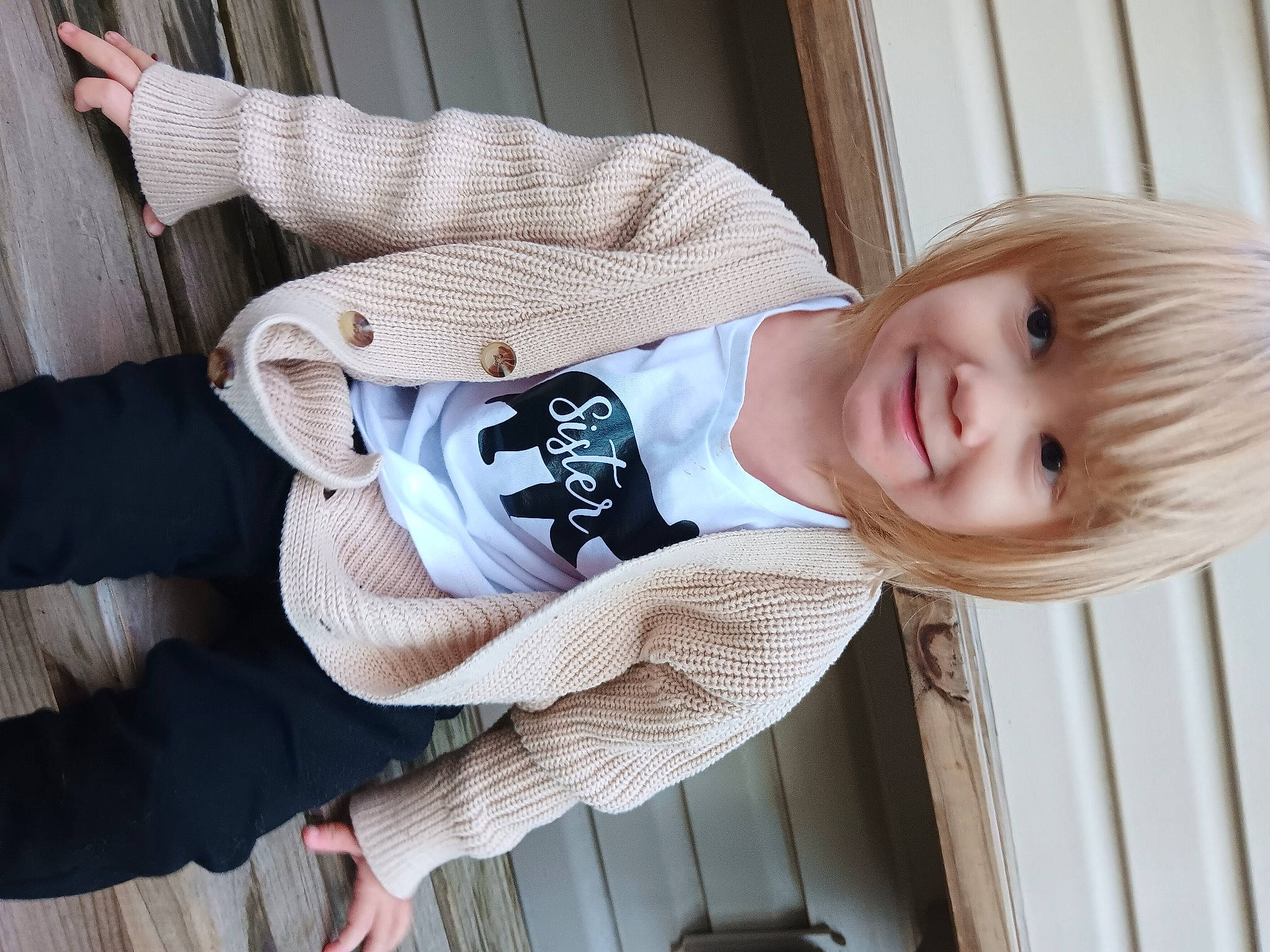 Braelynn is registered to the contest to win money with this photo: baby, baby_products, baby_toddler_clothing, cheek, child, collar, comfort, dress_shirt, elbow, eye, happy, joy, pattern, person, sitting, sleeve, smile, toddler, wood