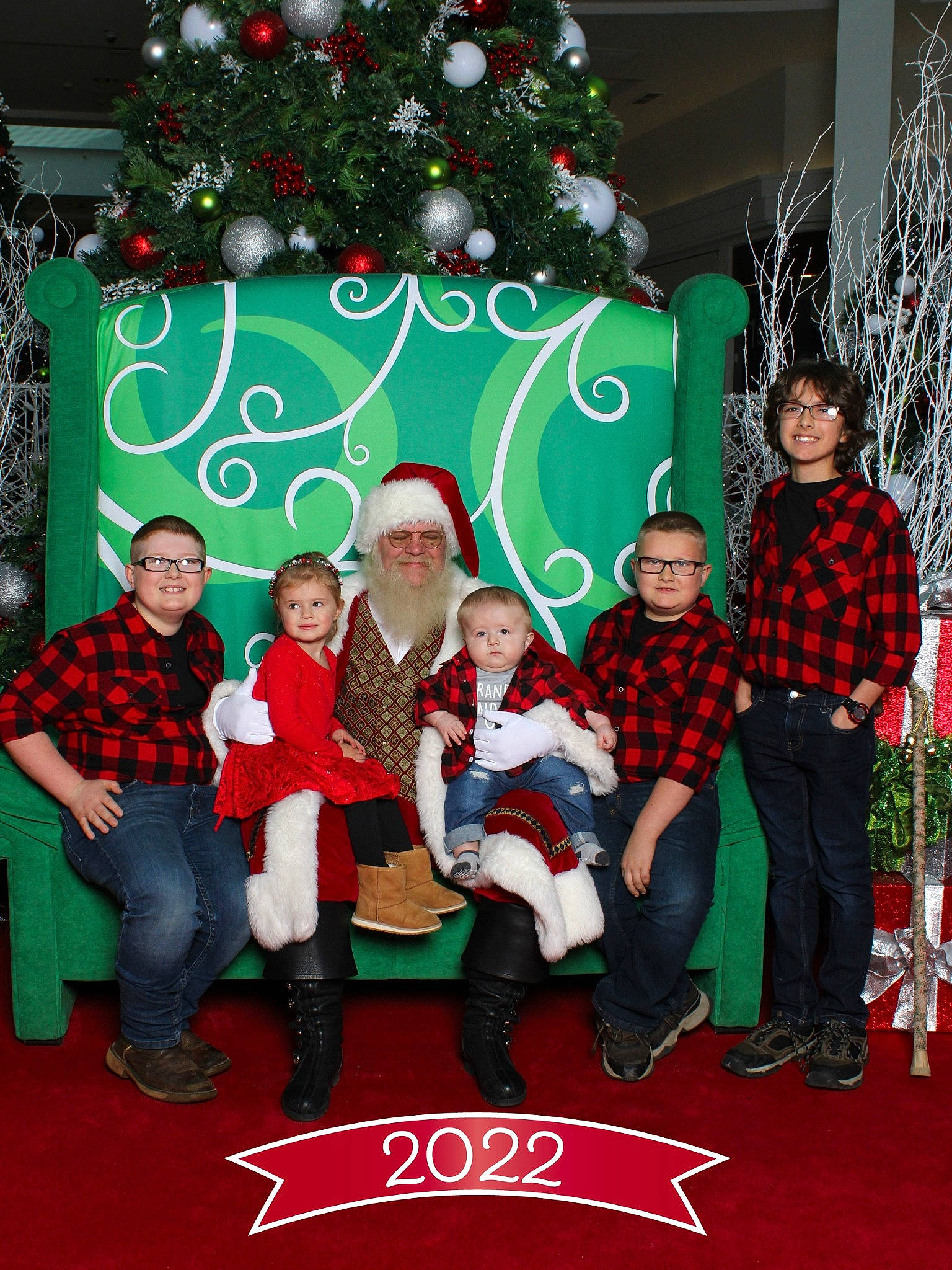 Annabelle is registered to the contest to win money with this photo: christmas, christmas_decoration, christmas_ornament, christmas_tree, decoration, event, facial_expression, fun, green, happy, headwear, holiday, holiday_ornament, interior_design, joy, lap, person, plant, red, smile