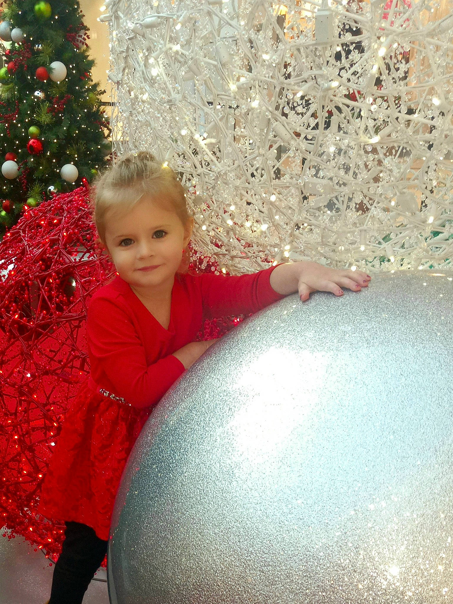 Annabelle is registered to the contest to win money with this photo: child, christmas_ornament, christmas_tree, event, eye, fun, happy, holiday, holiday_ornament, human_body, joy, leisure, ornament, people_in_nature, person, plant, red, standing, tints_and_shades, toddler
