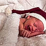 newborn, baby, smile, blanket, hat, knit_hat, infant, cozy, soft, cute, sleeping, wrapped, red, white, portrait, closeup, skin, hand, face, resting