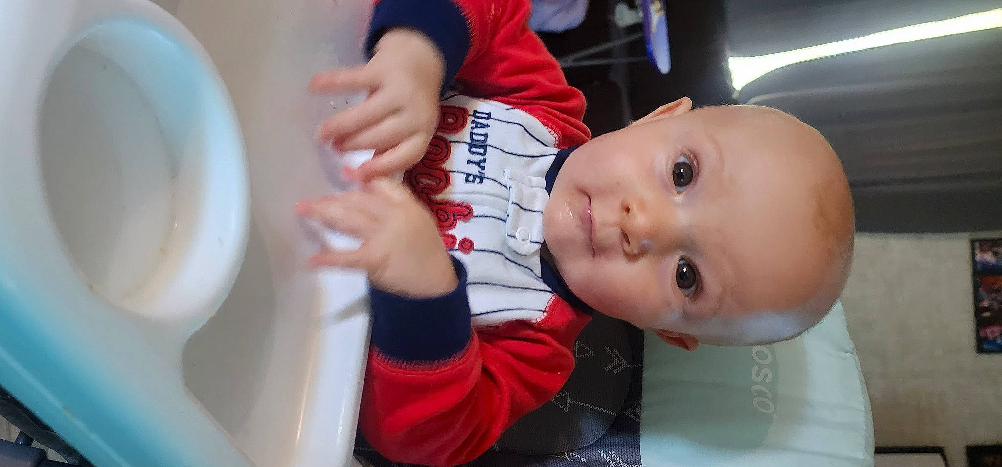 Reid is registered to the contest to win money with this photo: baby, baby_toddler_clothing, carmine, cheek, child, dishware, elbow, finger, fun, gesture, happy, nail, person, plate, serveware, sitting, skin, sleeve, t_shirt, thumb