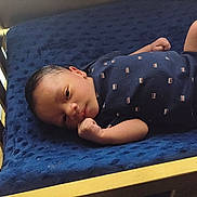 Tevon Xavier Brown joined the competition — help win amazing prizes! newborn, baby, infant, crib, wooden_crib, blanket, navy_blue, clothing, face, hand, fist, lying_down, indoors, portrait, cute, sleepy, baby_outfit, resting, child, person