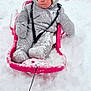child, baby, sled, pink_sled, snow, winter, snowsuit, hat, bundle, rosy_cheeks, sitting, outdoors, rope, play, mittens, boots, adult, background, red_sled, snow_play