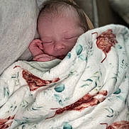 Violet is registered to the contest to win money with this photo: baby, newborn, sleeping, blanket, cozy, face, hand, soft, pattern, fabric, person, rest, peaceful, closeup, couch, comfort, indoor, infant, portrait, relaxation
