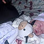newborn, baby, sleeping, plush_toy, cow, hat, striped_hat, blanket, soft_texture, cozy, infant, cute, peaceful, indoors, resting, child, clothing, pink, white, fabric