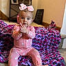 baby, child, pink_bow, pink_onesie, crocheted_blanket, stairs, indoor, carpet, clapping, cute, person, baby_girl, seated, expression, cozy, headwear, footed_pajamas, home, portrait, young_child