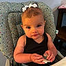 toddler, child, baby, high_chair, pacifier, bows, hair, face, expression, clothing, sitting, indoor, table, food, hand, furniture, person, cute, curious, polka_dot