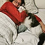person, cat, bed, blanket, pillow, glasses, red_sweater, white_cat, gray_cat, indoor, cozy, snuggling, resting, furniture, sleepwear, headboard, plush, comfort, relaxing, home