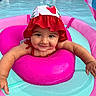 Shiloh joined the competition — help win amazing prizes! baby, child, infant, swimming_pool, inflatable_ring, water, hat, red, pink, blue, summer, smile, face, arms, cute, playful, outdoor, fun, floating, happy