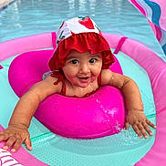 Shiloh is registered to the contest to win money with this photo: baby, child, pool, water, swimming, float, inflatable, hat, red, pink, turquoise, splashing, summer, outdoor, happy, smiling, face, arm, play, cute