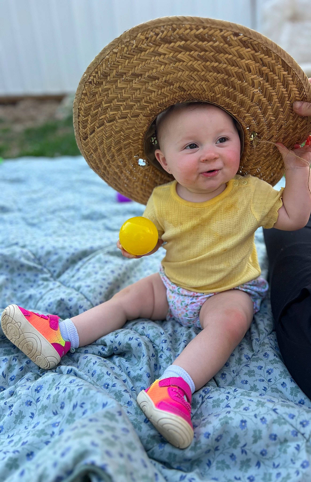 Paislee is registered to the contest to win money with this photo: baby, baby_toddler_clothing, cap, child, fashion_accessory, fun, grass, happy, hat, headwear, human_leg, leisure, people_in_nature, person, photograph, sitting, skin, smile, sneakers, sun_hat