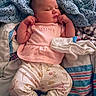 baby, sleeping, infant, blanket, clothing, pink, floral, cute, cozy, soft, newborn, person, portrait, peaceful, resting, indoors, child, fabric, text_on_clothing, sleepwear