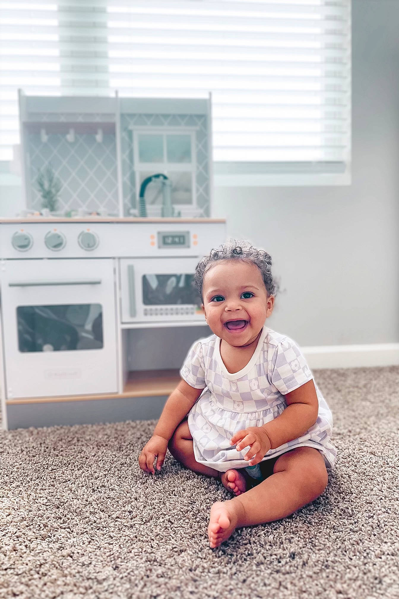Meadow is registered to the contest to win money with this photo: baby, baby_toddler_clothing, cabinetry, child, flash_photography, floor, flooring, fun, grass, happy, home_appliance, kitchen, pattern, person, sitting, smile, standing, t_shirt, toddler, window