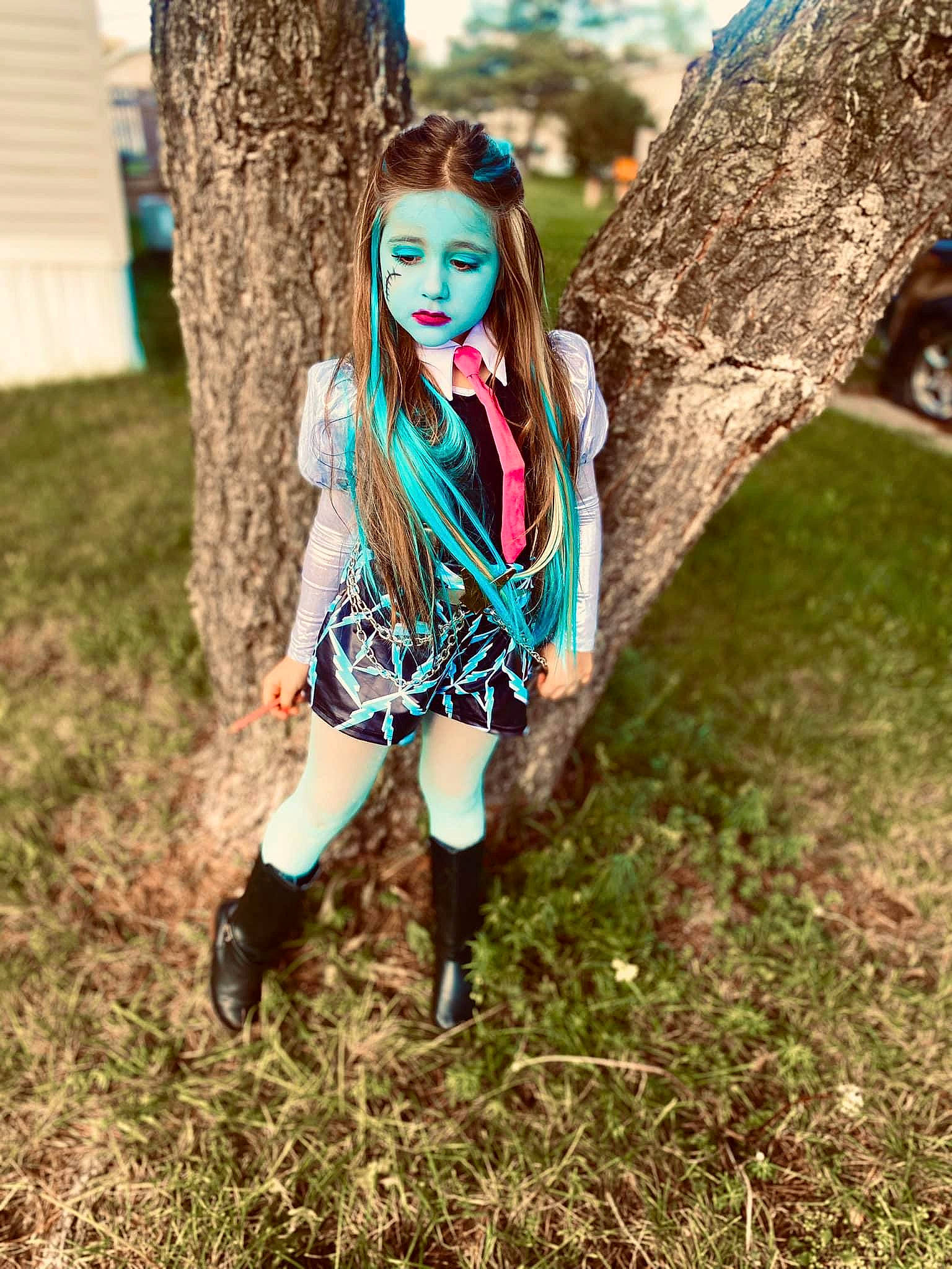 Makenna is registered to the contest to win money with this photo: bangs, barbie, black_hair, branch, doll, eye, eyewear, fashion_design, fawn, grass, happy, head, knee, people_in_nature, person, plant, sorrow, thigh, tree, wig