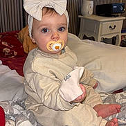 Kiara participe au concours pour gagner de l'argent avec cette photo : baby, bed, bedroom, blanket, bow, child, feet, flash_red_eye, headband, infant, nightstand, onesie, pacifier, pajamas, portrait, projector, quilt, sitting, sock, toes