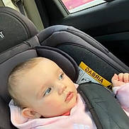 Kiara participe au concours pour gagner de l'argent avec cette photo : baby, child, car_seat, safety_harness, pink_hoodie, blue_eyes, infant, car_interior, window, seatbelt, child_safety, portrait, cute, young_child, car_travel, seat, headrest, soft_lighting, side_view, innocence