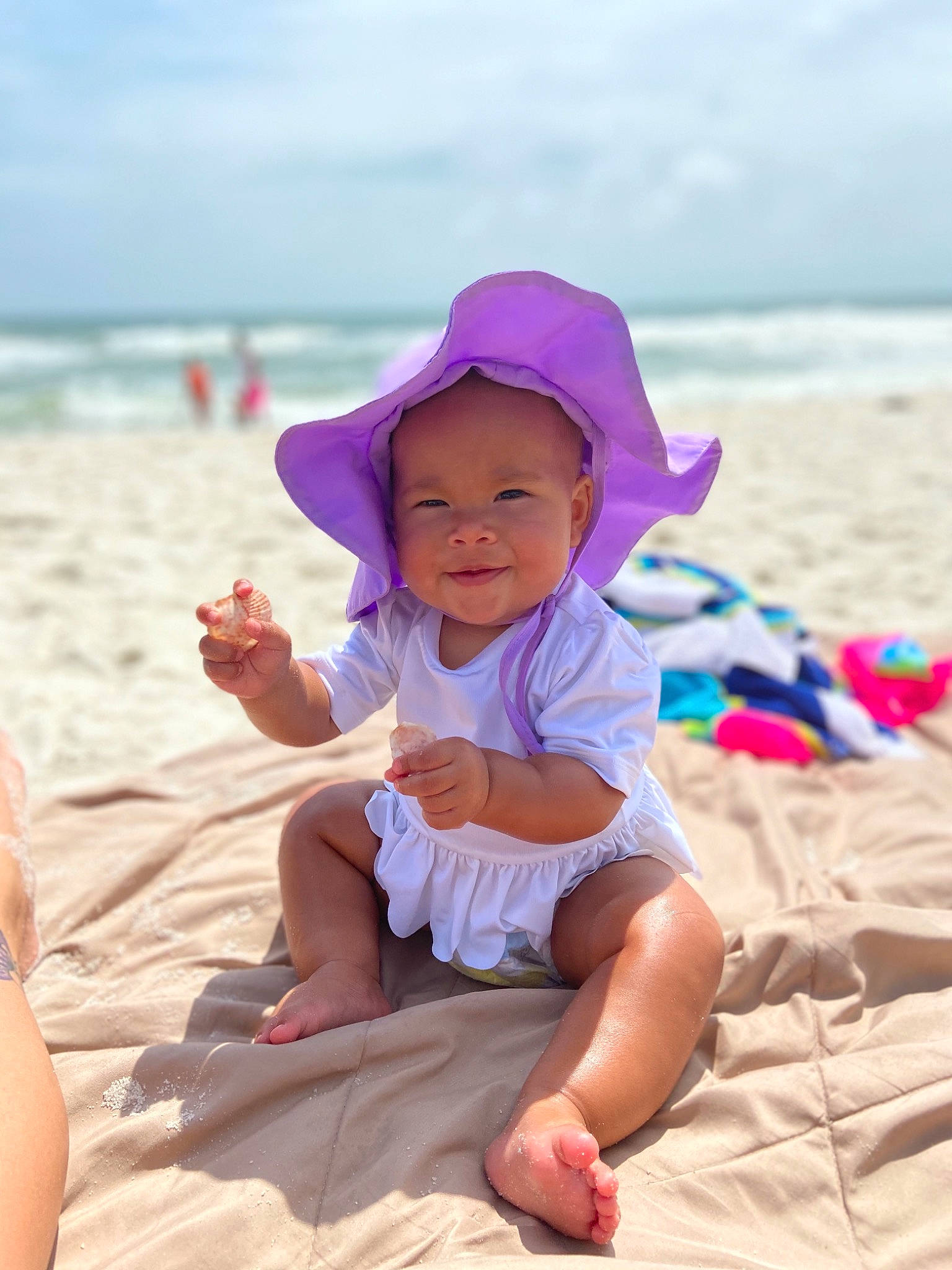 Milarose is registered to the contest to win money with this photo: baby, barefoot, beach, child, coast, fun, happy, headgear, headwear, joy, leisure, ocean, person, pink, play, sand, sea, sitting, smile, summer