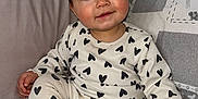 Thea is registered to the contest to win money with this photo: baby, child, heart_pattern, pajamas, toy, couch, pillow, indoor, smile, cute, infant, sitting, cozy, soft_lighting, portrait, happy, playful, young_child, comfortable, home