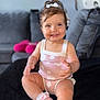 toddler, child, smiling, pink_outfit, pink_shoes, bow, sitting, indoor, couch, cushion, happy, baby, short_hair, cute, face, person, footwear, sock, living_room, portrait
