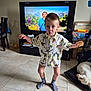 Léo participe au concours pour gagner de l'argent avec cette photo : child, boy, cookie, socks, shirt, floor, tile, dog, television, furniture, chair, room, indoor, expression, person, pet, playing, candid, home, napping