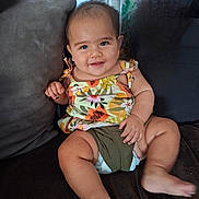 Ohana a rejoint le concours — aidez-le/la à gagner de superbes lots ! baby, child, smiling, sitting, couch, diaper, floral_top, cute, happy, indoors, furniture, person, skin, face, legs, arm, pillow, home, comfort, infant