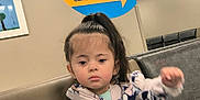 Denise is registered to the contest to win money with this photo: child, girl, portrait, waiting_room, clinic, medical_facility, signage, indoor, fleece_jacket, minnie_mouse, seated, facial_expression, ponytail, young_child, waiting_area, chair, person, casual_clothing, healthcare, pediatric