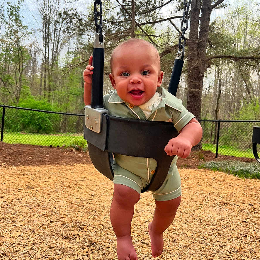 Jaevion is registered to the contest to win money with this photo: baby, backyard, clothing, face, grass, head, nature, outdoorplayarea, outdoors, park, person, photography, plant, playarea, portrait, shorts, swing, toy, tree, vegetation