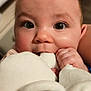 baby, close_up, face, eyes, hand, infant, plush_toy, soft_texture, cute, cheeks, indoor, child, skin, curious, mouth, expression, person, young, fingers, adorable