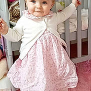Matilda Grace joined the competition — help win amazing prizes! baby, cardigan, child, crib, cute, dress, floor, furniture, happy, home, indoor, person, pink_rug, plush_toy, portrait, smiling, soft_toys, standing, toddler, unicorn