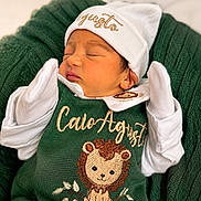 Caio Augusto joined the competition — help win amazing prizes! newborn, baby, sleeping, green_outfit, knitted_blanket, lion_embroidery, white_mittens, white_hat, cozy, cute, infant, portrait, soft_lighting, indoors, child, peaceful, warm, snuggled, clothing, baby_fashion