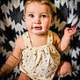 Delaney is registered to the contest to win money with this photo: baby, child, infant, romper, ladybug_pattern, pigtails, blue_eyes, blanket, black_and_white, pattern, cute, rosy_cheeks, sitting, indoors, portrait, skin, hand, legs, curious, expression