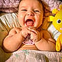 baby, laughing, pacifier, blanket, plush_toy, yellow, happy, child, infant, cute, smiling, hands, face, cozy, bed, soft, comfort, playful, joy, indoors