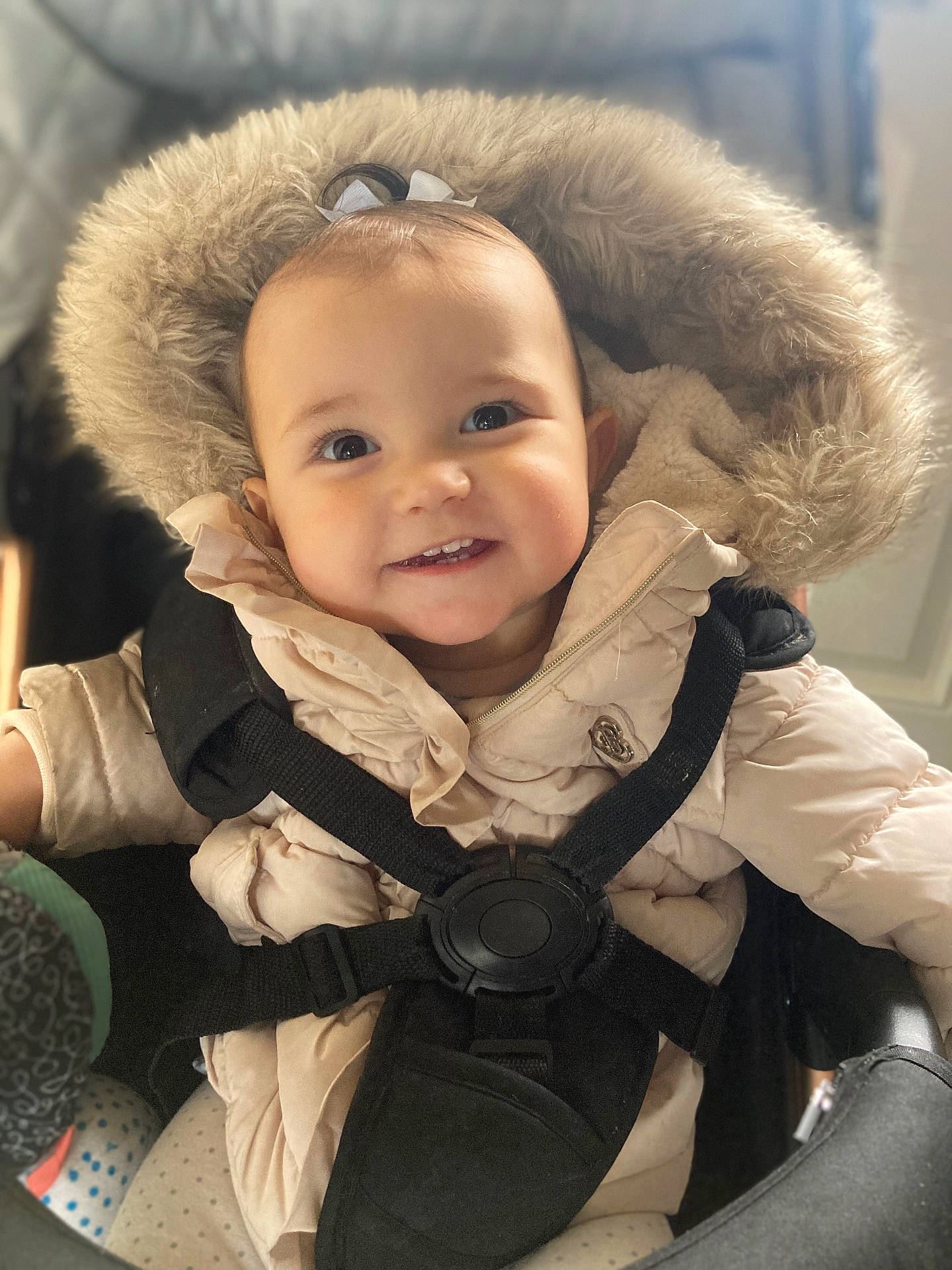 Freida is registered to the contest to win money with this photo: accessories, baby, car, car_interior, carseat, clothing, coat, face, happy, hat, head, hood, jacket, pants, person, photography, portrait, smile, transportation, vehicle
