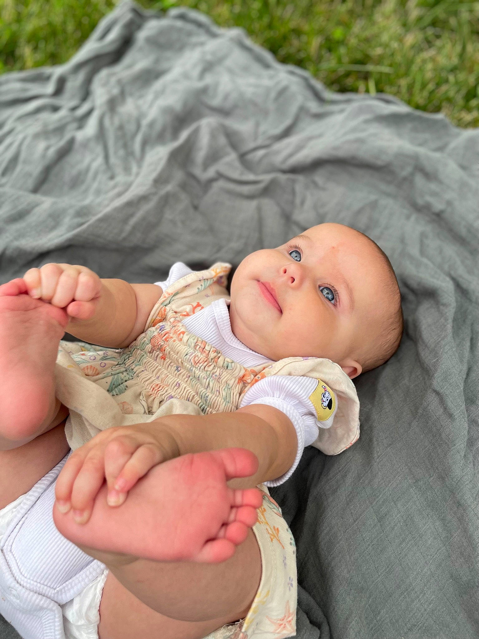 Everleigh Jean is registered to the contest to win money with this photo: abdomen, baby, baby_products, baby_toddler_clothing, cheek, child, comfort, foot, gesture, grass, happy, human_leg, pattern, person, portrait_photography, sitting, skin, stomach, thigh, thumb