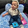Levi joined the competition — help win amazing prizes! toddler, child, bunny_ears, blue_chair, fluffy, marshmallow, peeps, jeans, suspenders, white_shirt, sneakers, indoor, curious, seated, candy, snack, cute, expression, person, portrait