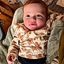 baby, child, infant, face, pajamas, blanket, indoors, cozy, cute, clothing, smiling, person, sitting, warm, soft, newborn, holiday, patterned_clothing, red_hair, comfort