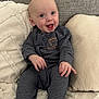Parker is registered to the contest to win money with this photo: baby, casual_wear, child, couch, cozy, cute, expression, eyes, face, happy, head, indoor, infant, person, pillow, seated, small_hands, smile, striped_clothing, young