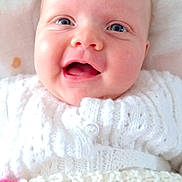 Océane a rejoint le concours — aidez-le/la à gagner de superbes lots ! baby, smiling, blue_eyes, knitted_sweater, white_clothing, blanket, polka_dots, close_up, face, infant, cute, happy, child, portrait, soft_texture, warmth, indoor, cozy, newborn, person