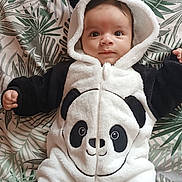 Khalid a rejoint le concours — aidez-le/la à gagner de superbes lots ! baby, panda_onesie, infant, child, cute, costume, hood, blanket, pattern, leafy, soft, footwear, lying_down, portrait, indoors, warm_clothing, smiling, face, young_child, cozy