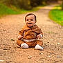 baby, bokeh, child, cute, dirt_path, eyes, fall, greenery, ground, happy, hoodie, infant, nature, one_person, outdoor, portrait, sitting, smiling, socks, trail