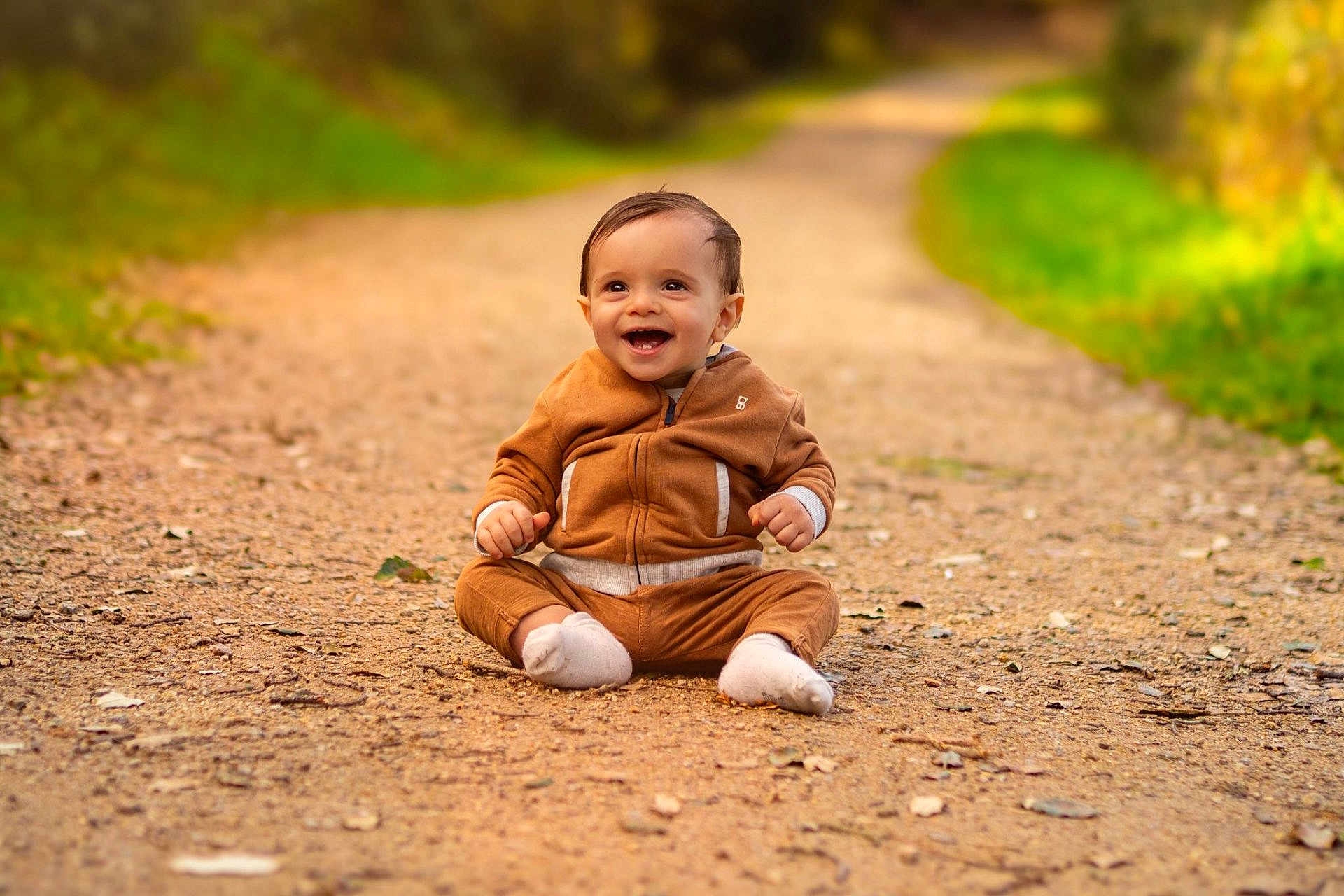 Nolan a rejoint le concours — aidez-le/la à gagner de superbes lots ! baby, bokeh, child, cute, dirt_path, eyes, fall, greenery, ground, happy, hoodie, infant, nature, one_person, outdoor, portrait, sitting, smiling, socks, trail